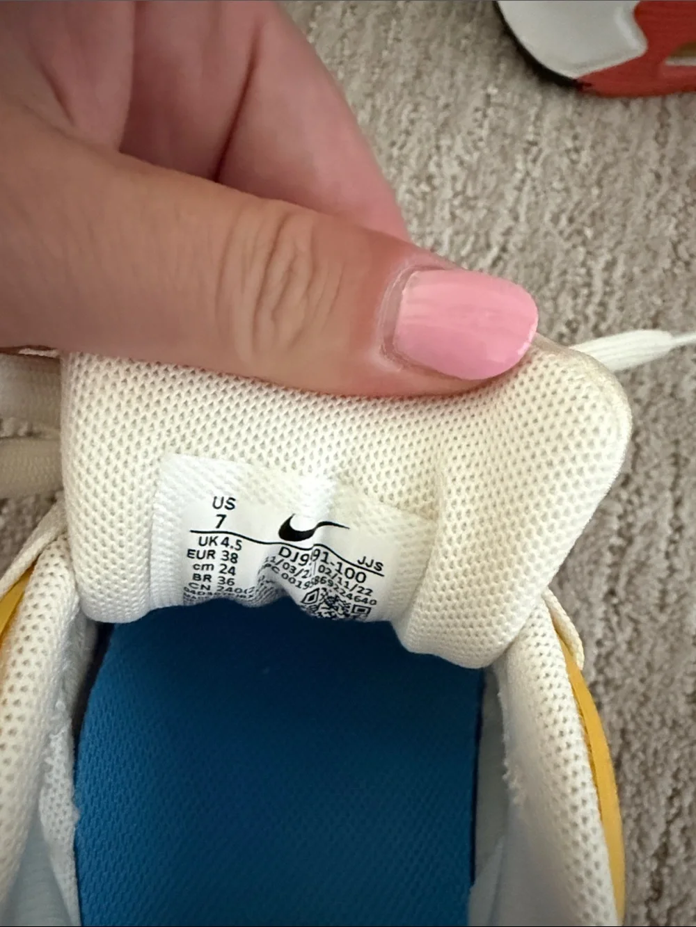 Nike White Sneakers with Blue Swoosh, Yellow Eyelets & Red Accents